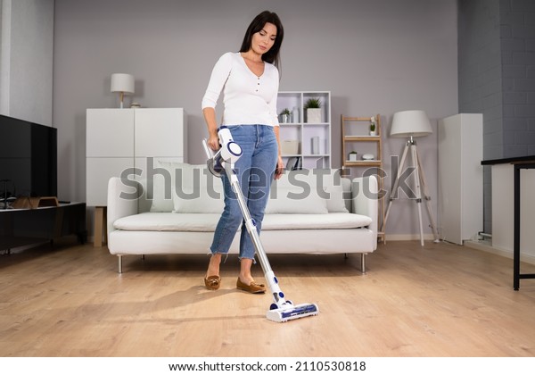 Young\
Maid Cleaning Floor With Handheld Vacuum\
Cleaner