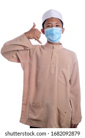 A Young Malay Boy Wearing A Malay Costume And Head Mask Isolated On White Background