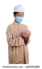 A Young Malay Boy Wearing A Malay Costume And Head Mask Isolated On White Background