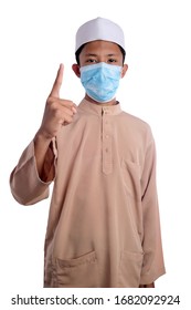 A Young Malay Boy Wearing A Malay Costume And Head Mask Isolated On White Background