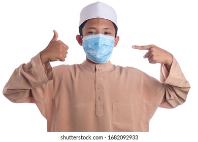 A Young Malay Boy Wearing A Malay Costume And Head Mask Isolated On White Background