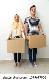 Young Malay Couple Holding A Box For House Moving