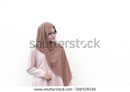 Young Malaysian lady with muslimah attire pose for camera isolated with white background.