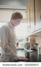 Young Male Adult Making A Cup Of Tea. Having Regular Cup Of Tea Before Work.