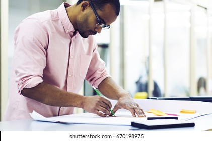 Young Male Architect Drawing Blueprint For Landscape Of City Park Making Measures And Accountings On Laptop Computer Connected To Wireless Internet Indoor While Thinking Over Better Planning Project