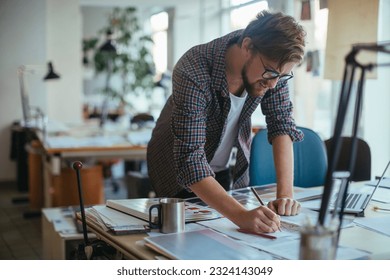 Young male architect working on a project in the office - Powered by Shutterstock