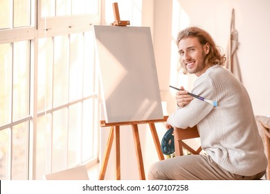 Young Male Artist Painting In Studio