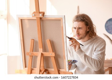 Young Male Artist Painting In Studio