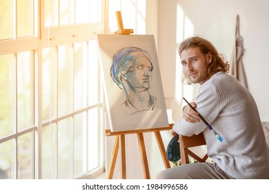 Young male artist painting in studio - Powered by Shutterstock