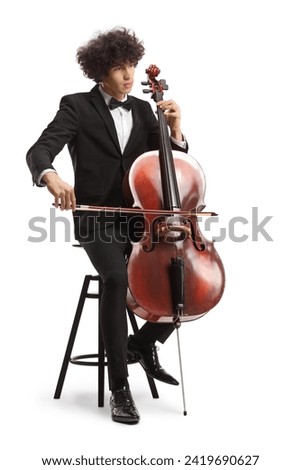 Young male artist sitting on a chair and playing a cello isolated on white background