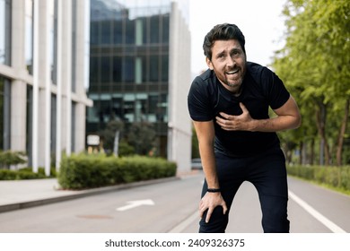 A young male athlete had a heart attack after running and exercising, holding his hands to his chest, feeling pain and shortness of breath. - Powered by Shutterstock