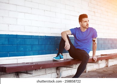 young male athlete sitting on the bench (intentional sun glare) - Powered by Shutterstock