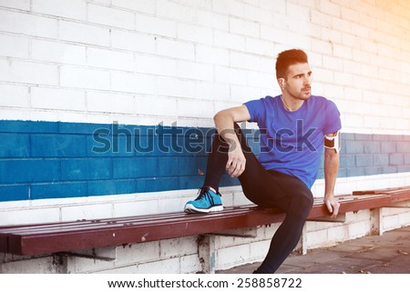 young male athlete sitting on the bench (intentional sun glare)