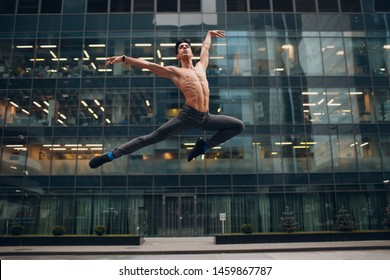 Young male ballet dancer jumping on a building background. Outdoor dance. - Powered by Shutterstock