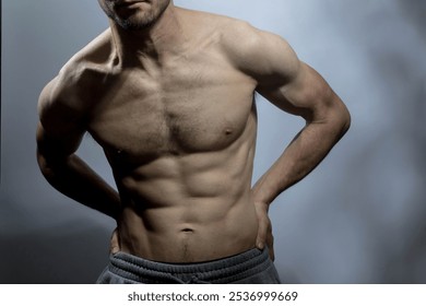 A young male body with well-defined abs and chest. Model with shirtless torso. Concept of body care, male health, fitness, youth, masculinity, health, weightloss, bodybuilding  - Powered by Shutterstock