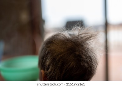 Young Male Boy Helping In The Kitchen With Messy Hair Sticking Up