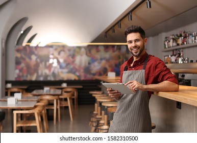 Young Male Business Owner With Tablet Near Counter In His Cafe. Space For Text