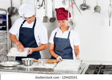 Young male chef with female colleague baking in commercial kitchen - Powered by Shutterstock