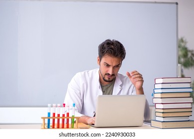 Young male chemist teacher in front of whiteboard