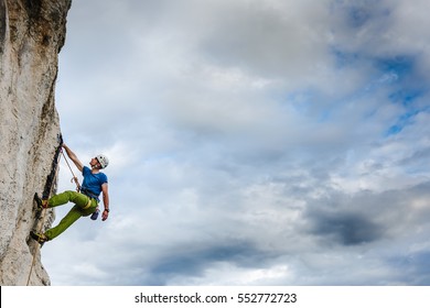 Young male climber hanging by a cliff - Shutterstock ID 552772723