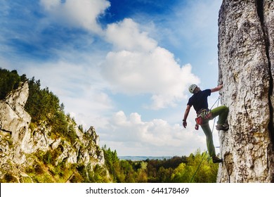 Young Male Climber Hanging By A Cliff