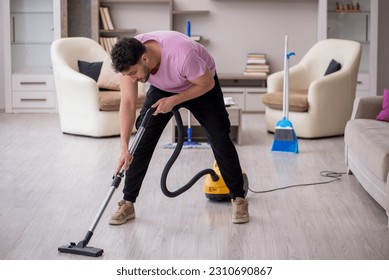 Young male contractor cleaning the house - Shutterstock ID 2310690867