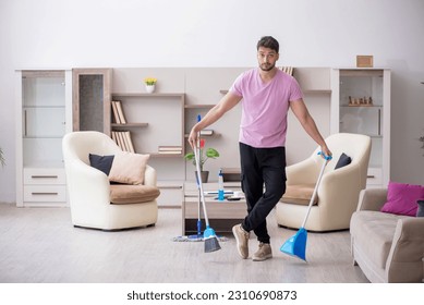 Young male contractor cleaning the house - Shutterstock ID 2310690873