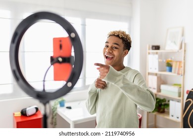 Young male creator recording online media video on his room - Millennial guy streaming online and sharing social media content by mobile phone app network - New trends for millennial people concept - Shutterstock ID 2119740956