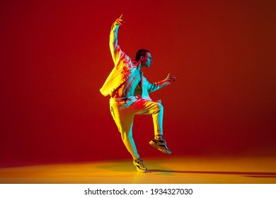 Young Male Dancer Dancing Hip-hop Isolated Over Red Background In Neon Light