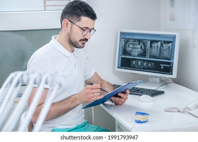 Young Male Dentist At His Office Looking Busy