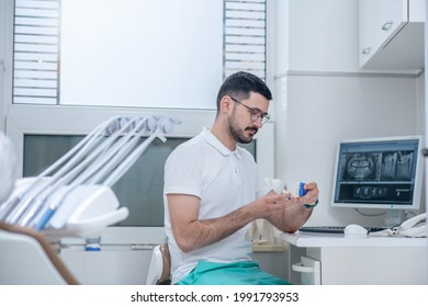 Young Male Dentist At His Office Looking Busy