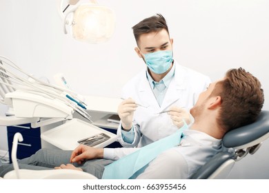 A Young Male Dentist And A Patient. Dentist Office Lifestyle Scene. Doctor Practice. Patient Health Care