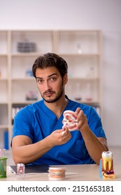 Young Male Dentist Working In The Clinic