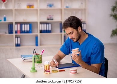 Young Male Dentist Working In The Clinic