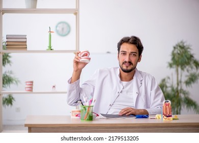 Young Male Dentist Working In The Clinic