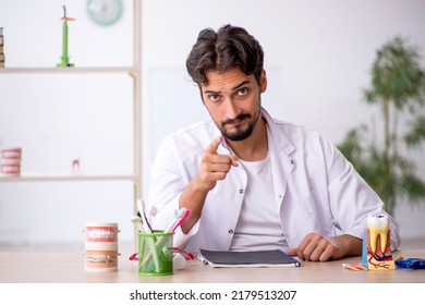 Young Male Dentist Working In The Clinic