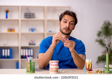 Young Male Dentist Working In The Clinic