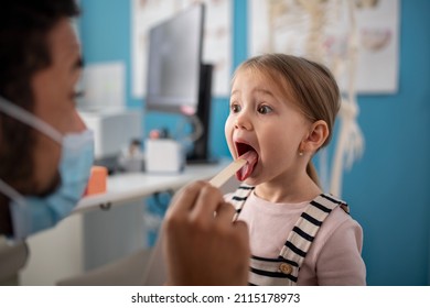 Young male doctor checking little girl's throat in his office. - Powered by Shutterstock