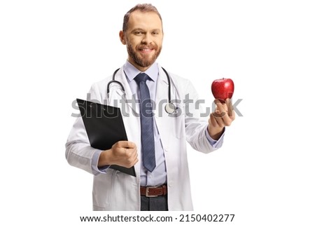 Young male doctor holding a clipboard and a red apple isolated on white background 