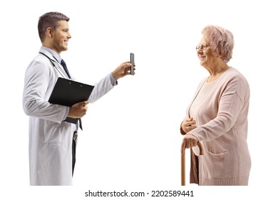 Young Male Doctor Showing A Mobile Phone To An Elderly Woman Isolated On White Background 