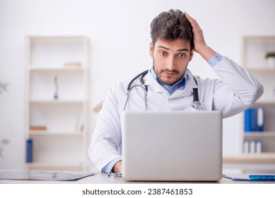 Young male doctor in telemedicine concept - Powered by Shutterstock