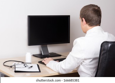 young male doctor working with computer in modern office