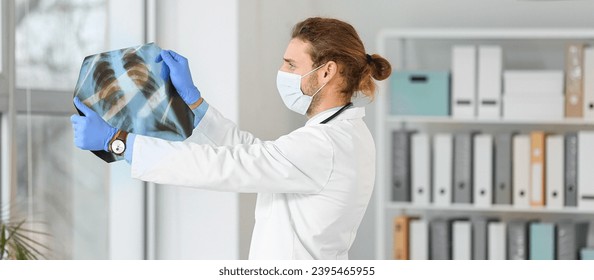 Young male doctor with x-ray image of chest in clinic - Shutterstock ID 2395465955