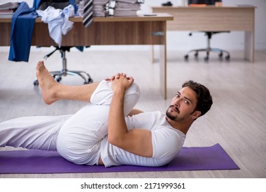 Young Male Employee Doing Sport Exercises In The Office