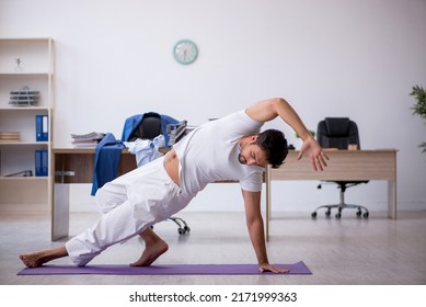 Young Male Employee Doing Sport Exercises In The Office