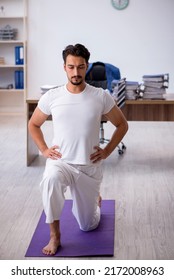 Young Male Employee Doing Sport Exercises In The Office