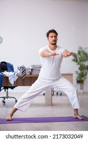 Young Male Employee Doing Sport Exercises In The Office