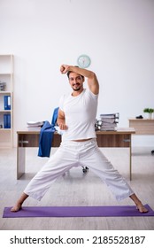 Young Male Employee Doing Sport Exercises In The Office