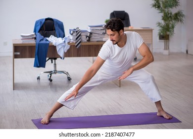 Young Male Employee Doing Sport Exercises In The Office