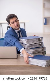 Young male employee and too much work in the office - Shutterstock ID 2254499765